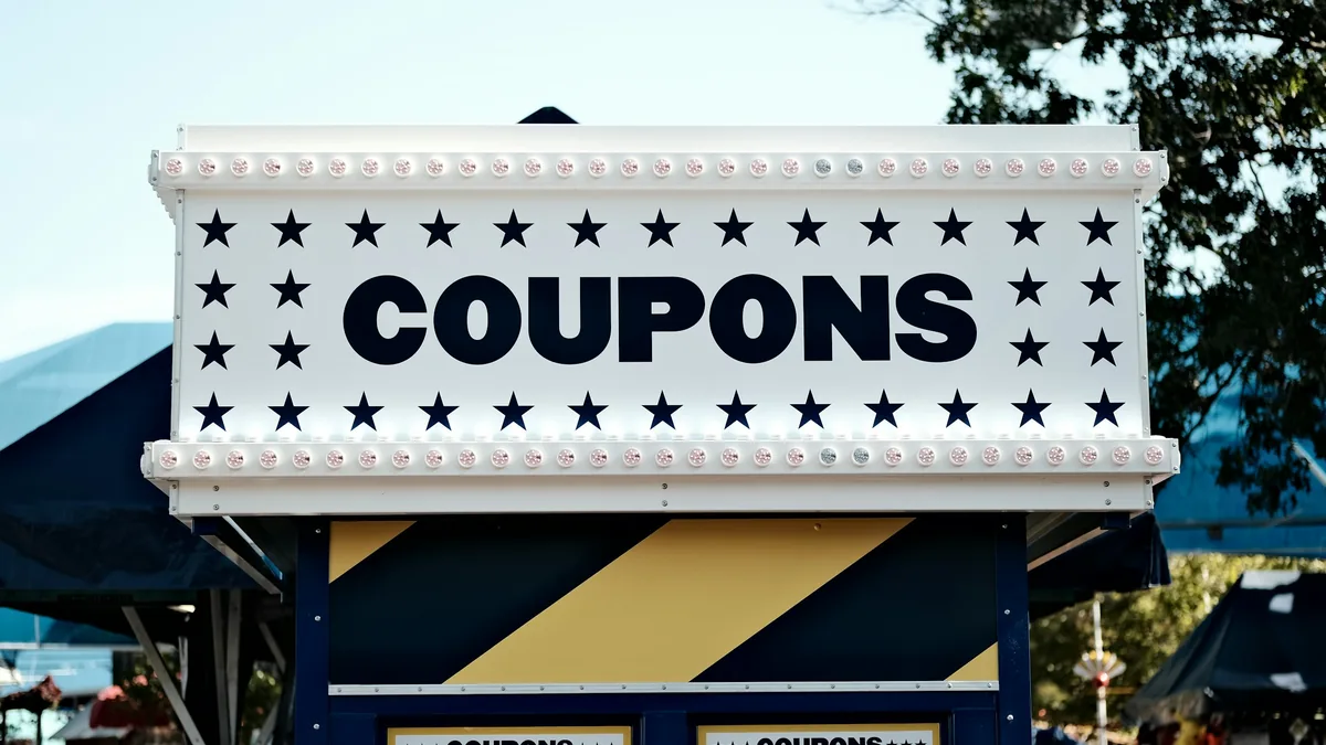 Una caseta de feria con un letrero luminoso que dice COUPONS